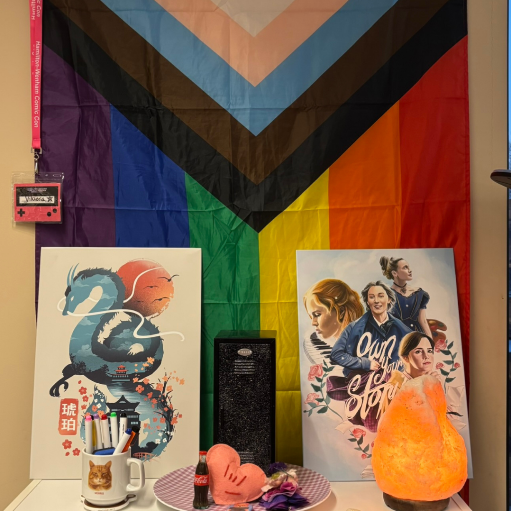 Photo of a pride flag and several knick knacks on a table with a salt lamp.