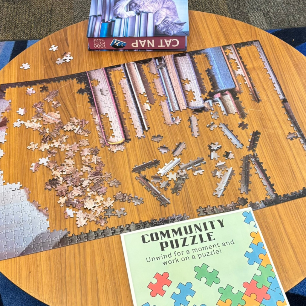 Photo of a partially completed puzzle with a sign that reads "Community puzzle."